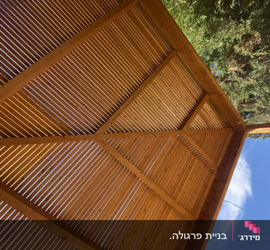גג עץ עם קורות עץ וחריצים לאור השמש